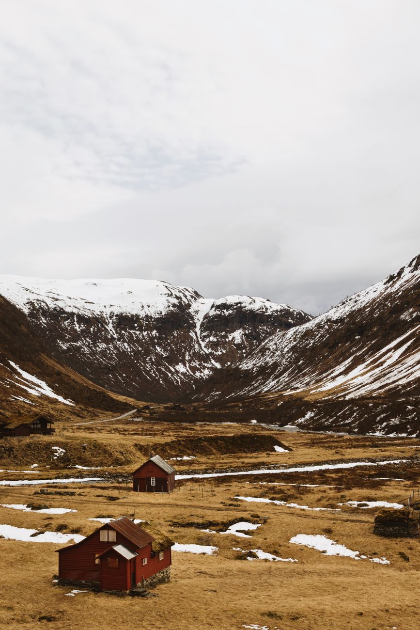 Norwegian wooden shelter overlooking a deep fjord at dawn